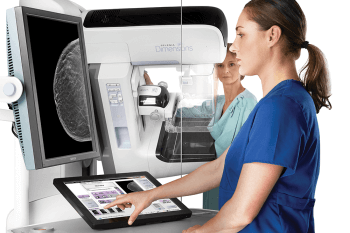 nurse viewing a 3d mammography machine
